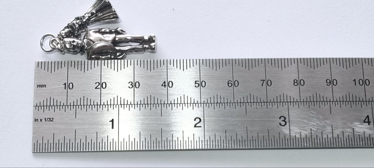 Bride figure and Frankenstein charm against ruler